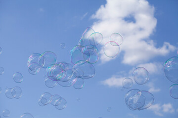 Giant soap bubbles floating against the blue sky. and white clouds.