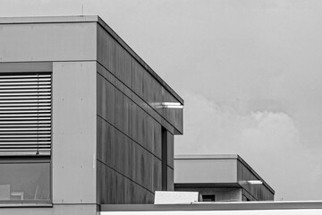 Modern architecture showing geometric shapes and a cloudy sky in monochrome