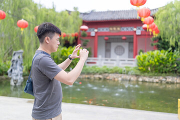 A Chinese Malaysian couple in their 30s spends time in a Chinese garden in Kuala Lumpur, Malaysia. A sunny afternoon in June 2024.