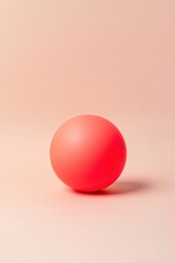 Vibrant red sphere against a soft peach background
