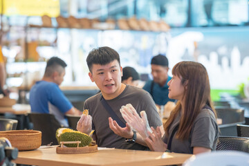 June 2024. A Chinese-Malaysian couple in their 30s chat while eating durian at a famous restaurant popular with tourists in Kuala Lumpur, Malaysia.
