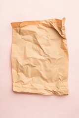 crumpled brown paper bag on pink background