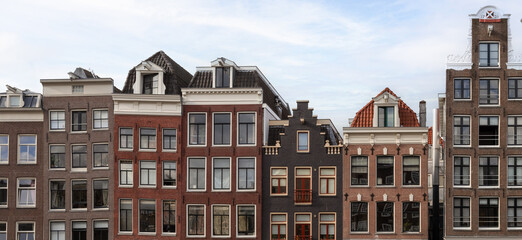 Obraz premium Narrow canal houses with different facades next to each other in the center of Amsterdam.