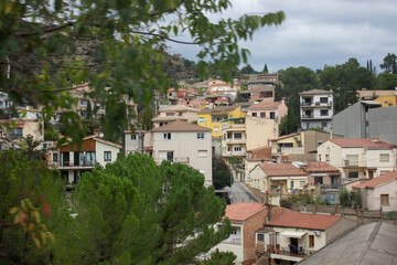 view of the village near the mountain. Many different houses, streets, gardens. The houses have balconies, windows.