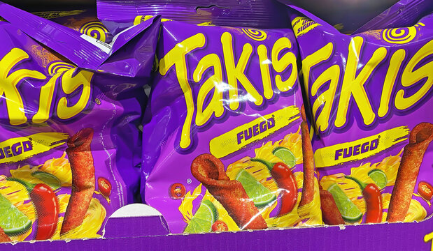 Viersen, Germany - November 5. 2024: Closeup of bags Takis Fuego lemon chili chips rolls in german store shelf (focus on center)