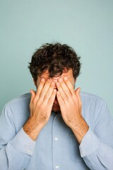 Distressed man covering face with hands