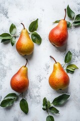 Obraz premium Ripe pears with green leaves on a light background