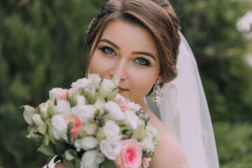 Naklejka premium A woman is posing with a bouquet of flowers and a veil. She has a beautiful smile on her face
