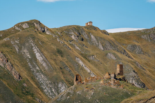 View on the Abano chapel and the Zakagori medieval fortress perched on mountains in the Truso Gorge of the Kazbegi region of Georgia