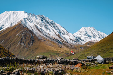 The border checkpoint with South Ossetia at the end of Truso Valley, a Georgian flag flying and snow capped peaks in the background, near Kazbegi in Georgia