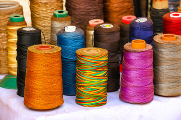 Colorful treads, bobbins, reels, spools on the street market in Arambol, Goa, India.