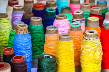 Colorful treads, bobbins, reels, spools on the street market in Arambol, Goa, India.