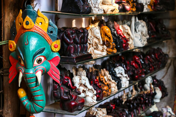 Colorful masks and statuettes for sale in the street shop. Shopping in Arambol, Goa, India.