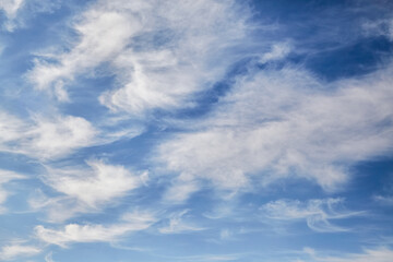 Fluffy white clouds in the afternoon blue sky, celestial background, celestial landscape.