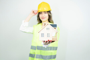 Home inspector woman or engineer holding a helmet and single-family home or detached house model isolated on white background