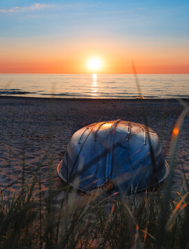  beach scene at sunset, with a boat resting on the sand