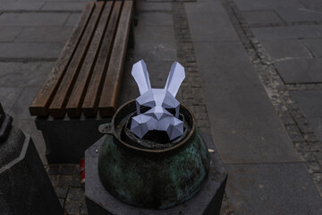 Paper rabbit head is sitting in a metal container