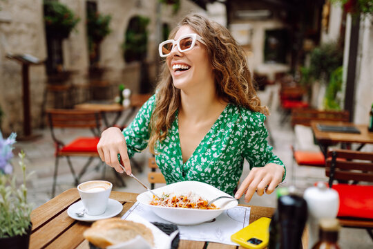 Fototapeta Woman eating italian pasta and drinking coffee at restaurant on the street in Rome. Concept of Italian gastronomy and travel.