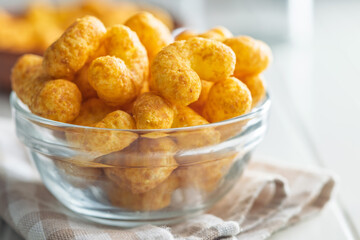 Puffed crispy Peanut flips in bowl on white table.