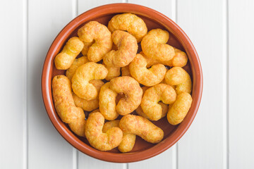 Puffed crispy Peanut flips in bowl on white table.
