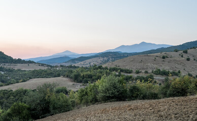 Fototapeta premium Permet, Albania - August 14 2024: Remote and rugged mountainous landscape along challenging SH75 road between Berat and Permet, showcasing the wild beauty of Albania's dramatic terrain. Summer evening