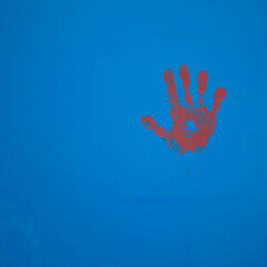 empreinte de main rouge sur fond bleu