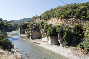 Corovoda, Albania - August 15 2024: Scenic view of the Osumi River canyon and connecting rugged shoreline from suspension foot bridge Corovode. 