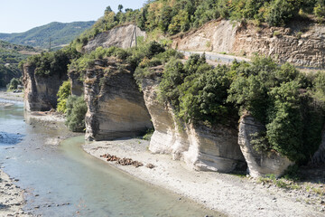 Corovoda, Albania - August 15 2024: Scenic view of the Osumi River canyon and connecting rugged shoreline from suspension foot bridge Corovode. 