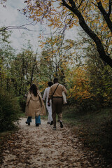 Obraz premium A group of friends enjoying a walk together on a scenic forest trail surrounded by autumn foliage, capturing moments of connection and natural beauty.
