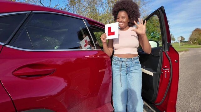Hampshire England UK. 01.11.2024. Video.  Happy learner driver passes driving test and is seen here dancing for joy holding the L plate.