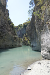 Osumi Gorge, Albania - August 15 2024: Stunning view of Osumi Canyon (Albanian: Kanioni i Osumit), showcasing the breathtaking cliffs, vibrant greenery, and winding river through dramatic landscape.