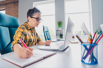 Photo of pretty senior female write notebook laptop wear plaid yellow shirt coworking successful...