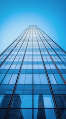 Obraz premium A tall glass building reaching towards the clear blue sky on a bright sunny day in the city