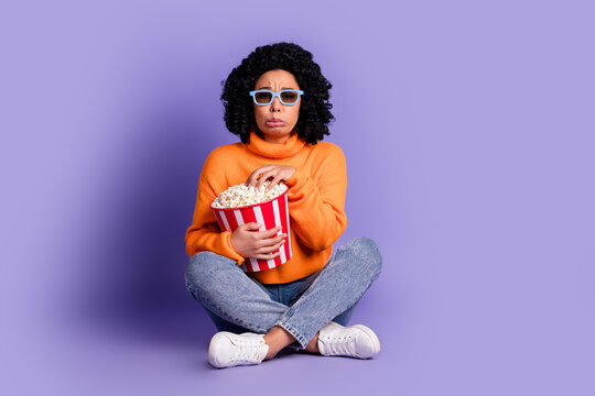 Full length photo of scared funy lady dressed knitted sweater watch movie enjoy pop corn isolated purple color background