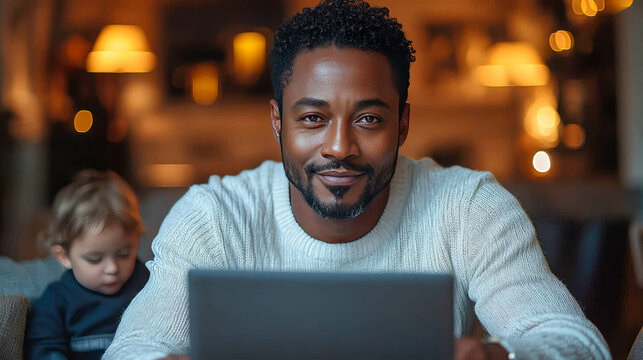 African-American man working on laptop with his daughter beside him, depicting family bonding and modern work-from-home life