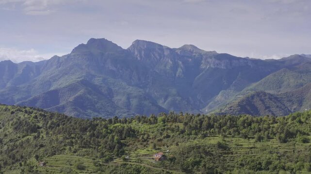 Mountains and Green Hills in Liguria: Aerial Drone View on a Bright Day with Blue Sky &ndash; Drone Flyover Dolly Out