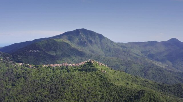 Mountain Village Chuch in Liguria: Drone View of Italy&rsquo;s Green Hills and Mountain Panorama on a Bright Day with Blue Sky &ndash; Wide Shot Drone Flyover Tracking Left