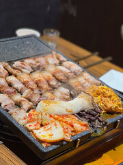 돌판 위에 구워진 삼겹살과 한국 스타일 가니쉬