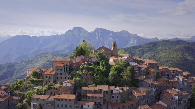 Mountain Village in Liguria: Drone View of Italy&rsquo;s Green Hills and Mountain Panorama on a Bright Day with Blue Sky &ndash; Medium Shot Drone Flyover Tracking Right