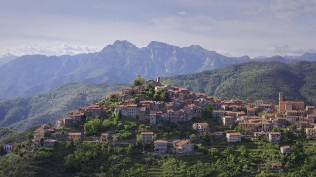 Mountain Village in Liguria: Drone View of Italy&rsquo;s Green Hills and Mountain Panorama on a Bright Day with Blue Sky &ndash; Wide Shot Drone Flyover Tracking Left