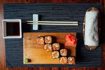 A plate of sushi with chopsticks and a dipping sauce