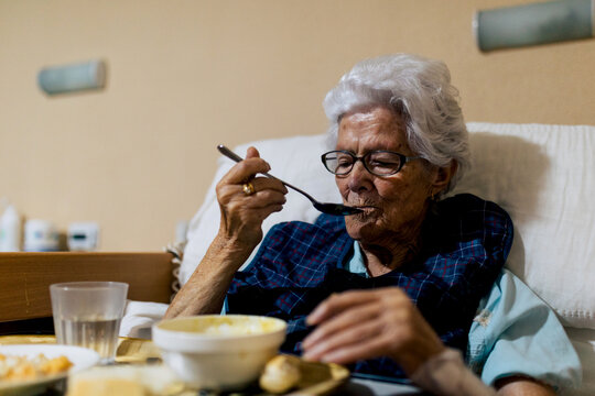 Senior Woman Enjoying Meal in Residential Care Setting