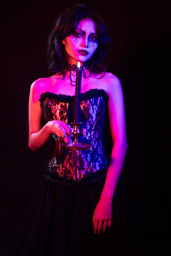 Gothic Woman Holding Candle in Dark, Mysterious Setting