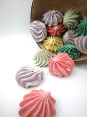 Close up of meringue cookies spilling out of wooden bowl