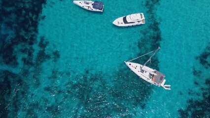 Boats floating in the crystal clear turquoise sea water. Blue lagoon, Comino, Maltese Islands. Aerial high angle view. High quality photo