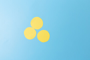 three yellow circles sitting on top of a blue surface, minimalism, paper decoration, top view, part of making kids craft easy origami,