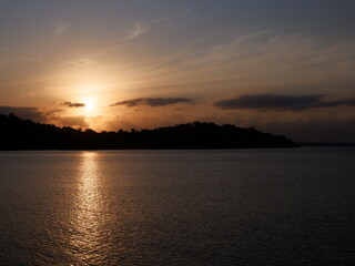 Naklejka premium Stunning sunrise over Kotabaru beach, South Kalimantan, casting golden light on tranquil waters and creating a serene coastal scene