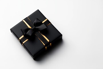 Stylish black gift box with gold ribbon on a white isolated background.