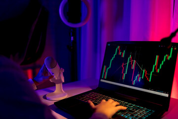Boy trading on laptop with financial charts displayed