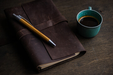 Top view of coffee cup and notebook on wooden table